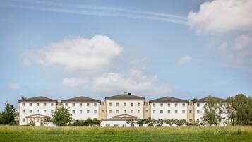 A large, multi-story hotel with a symmetrical facade, evenly spaced windows, and a central entrance with a pediment.