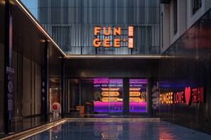 A modern building with a prominent 'FUN GEE' sign, a glass facade, and a reflective pool in front. - FUNGEE X Hotel - Shenzhen Huaqiangbei (Shenzhen)