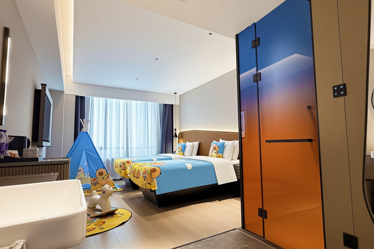 Una habitación de hotel moderna con cama, escritorio, espejo y baño.