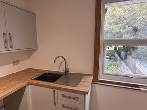 Eine Küche mit Spüle, Holz Arbeitsplatte und Schränken.