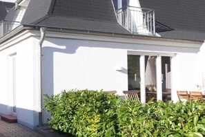 Ein weißes Gebäude mit Balkon, Tür und Fenster.
