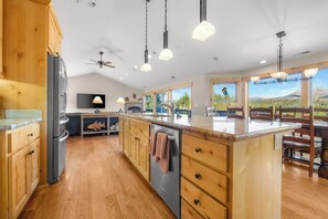 A modern kitchen with wooden cabinets, a central island, and a view of the outdoors. - Shaquinaw - Mountain views, Hot tub & Game Room! (South Lake Tahoe)