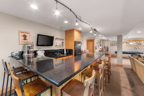 A modern kitchen with a central island, bar seating, and a Star Wars themed wall. - Shaquinaw - Mountain views, Hot tub & Game Room! (South Lake Tahoe)