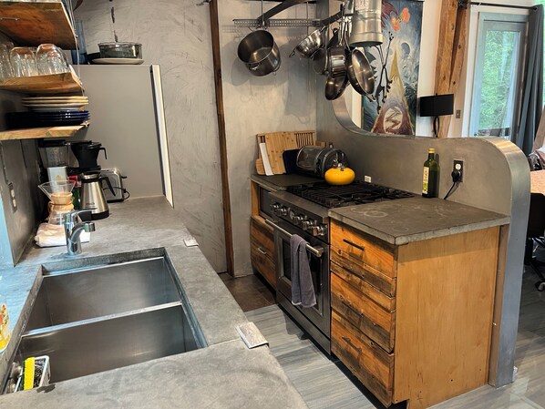 Une cuisine équipée d’un évier en acier inoxydable, d’une cuisinière et d’un meuble en bois.