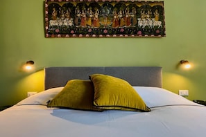 Ein Bett mit zwei Kissen, einem Kopfteil und einem Wandbild.
