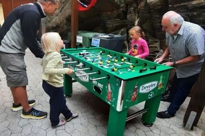 A group of people playing foosball at a table with a Develery logo. - Old Forester's Lodge Holiday Apartment Bianca (Bad Peterstal)