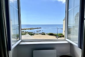 Ein Fenster mit Blick auf Strand und Meer.