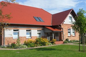 A two-story house with a red roof, brick exterior, and a small porch. - Old School Ahrensberg (Ahrensberg)