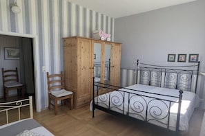 A bedroom with a bed, a wooden wardrobe, a chair, and a small table. - Old School Ahrensberg (Ahrensberg)
