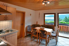 A kitchen with a sink, cabinets, and a dining area with a table and chairs. - Holiday apartment with 2 bedrooms (Oppenau)