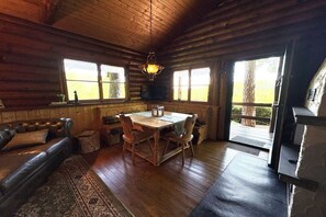 A log cabin interior with a dining area, a sofa, and a fireplace. - Blankenborn log cabin (Bad Bergzabern)