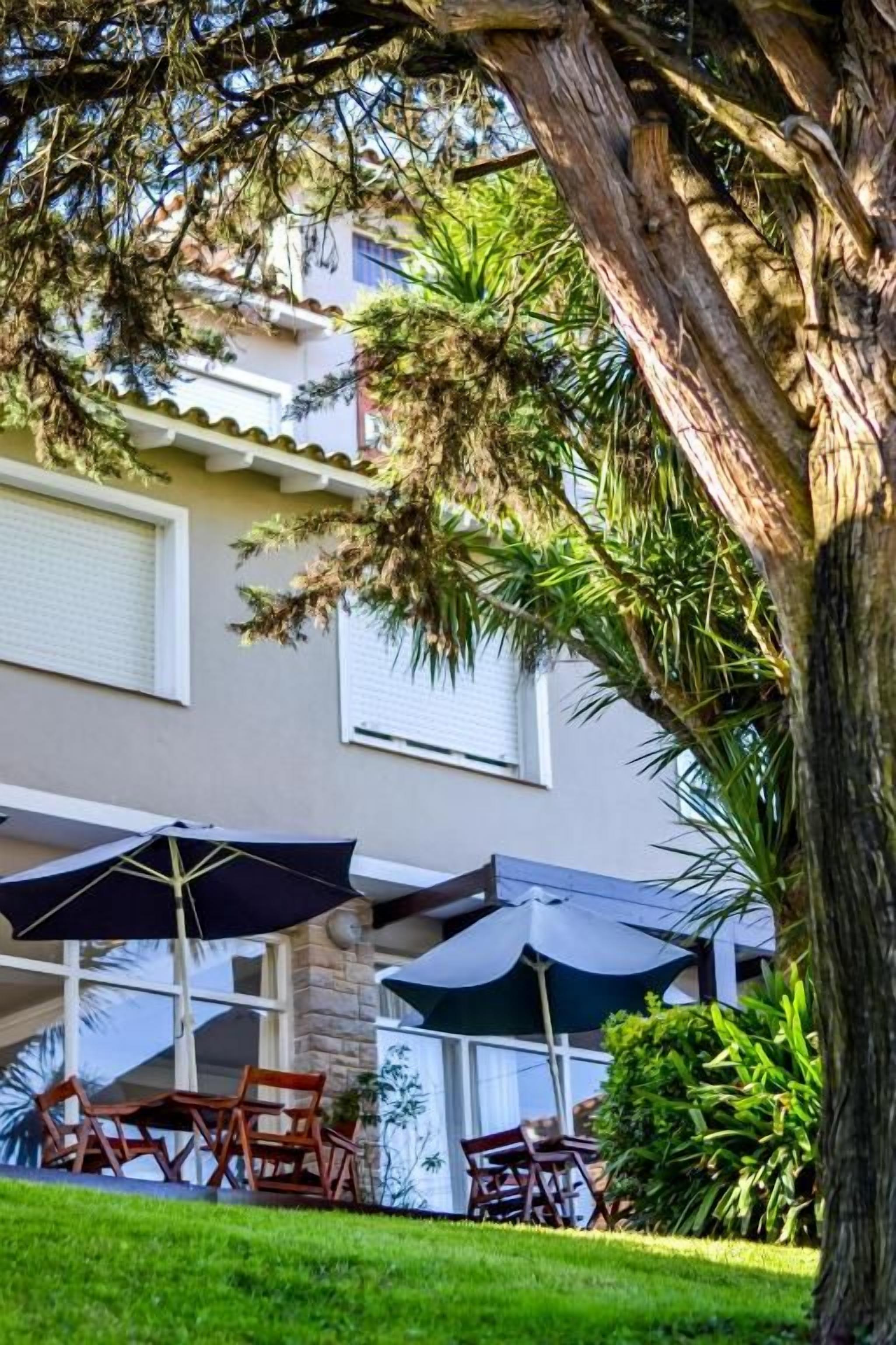 Un edificio con terraza y un árbol.