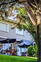 Un edificio con terraza y un árbol.
