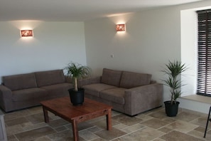 Ein Wohnzimmer mit zwei Sofas, einem Couchtisch und zwei Zimmerpflanzen.