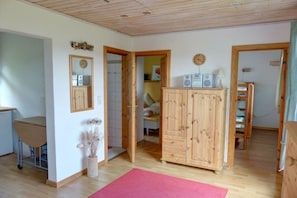 A room with a wooden cabinet, a desk, and a bed in the background. - Holiday home with 1 bedroom (Marienberg\/OT Rittersberg)