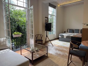 Ein modernes Hotelzimmer mit Balkon, Bett, Schreibtisch und Stuhl.