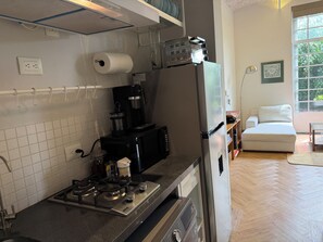 Eine Küche mit Gaskochfeld, Kaffeemaschine und Kühlschrank.