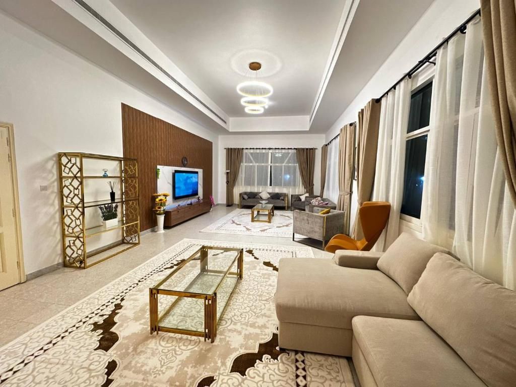 Una sala de estar moderna con un sofá, televisión y objetos decorativos.