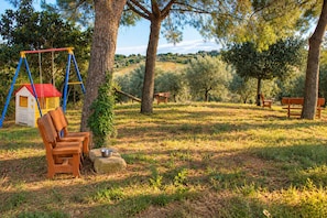 A park with a swing set, benches, and picnic tables. - Cetine Vecchie Farmstay – The Winery (Torrita di Siena)