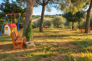 A park with a swing set, benches, and picnic tables. - Cetine Vecchie Farmstay – Il Giglio (Torrita di Siena)