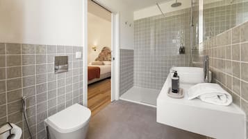 Une salle de bain moderne équipée de toilettes, d’une douche et d’un lavabo.