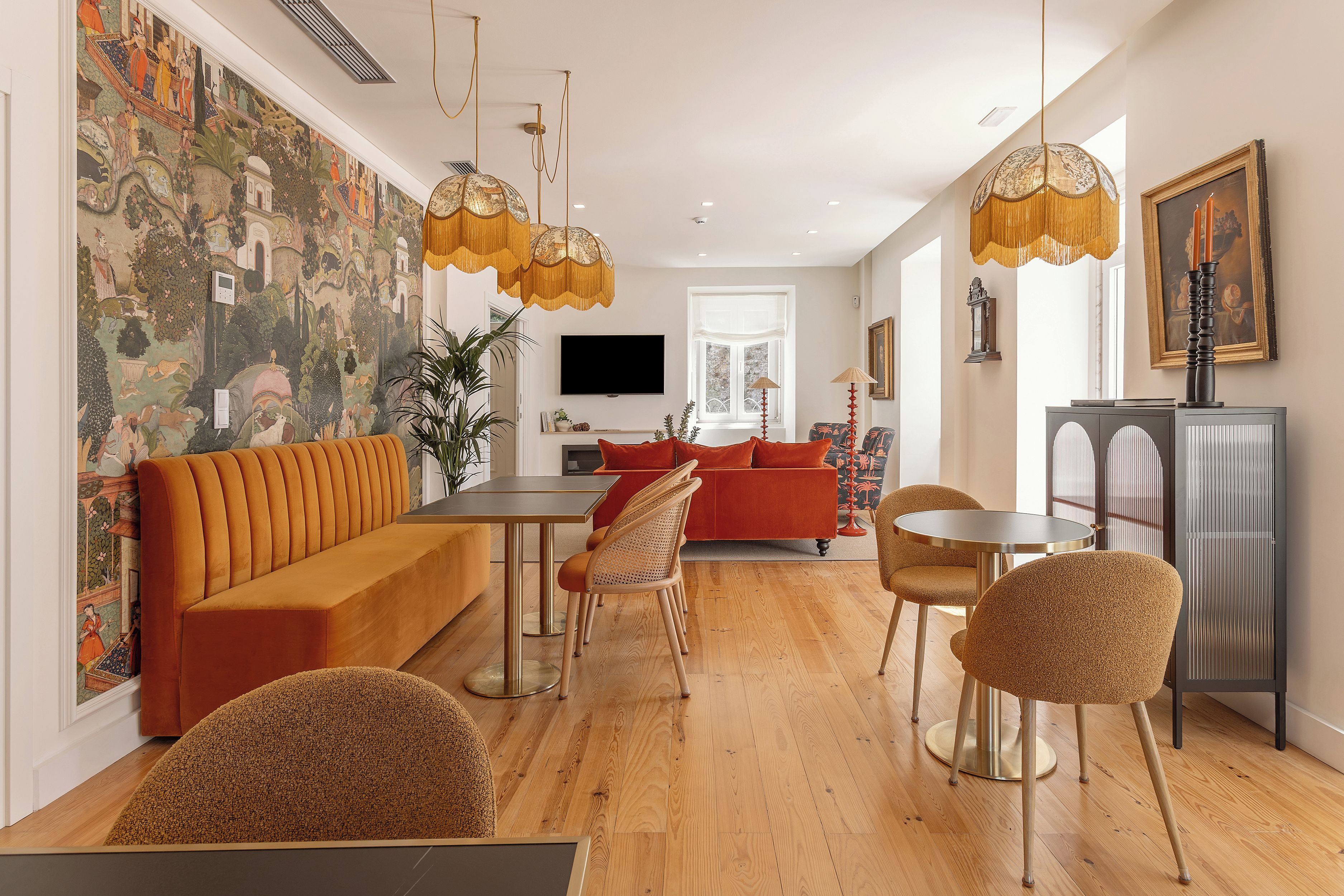 A modern living room with a sofa, dining table, chairs, and a TV.