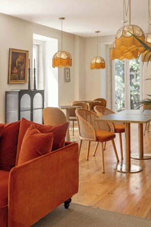 Una sala moderna con sofá, mesa de comedor, sillas e iluminación colgante.