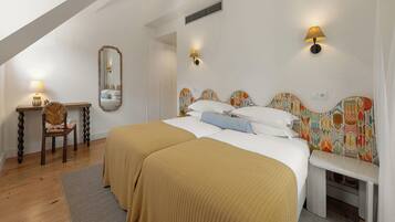 A bedroom with a large bed, a bedside table, a chair, and a mirror.