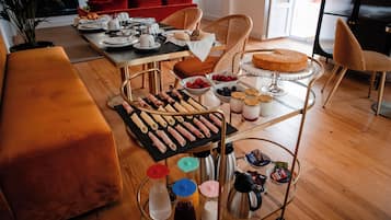 Ein Frühstücksbuffet mit Croissants, Gebäck und verschiedenen Früchten auf einem Tisch.