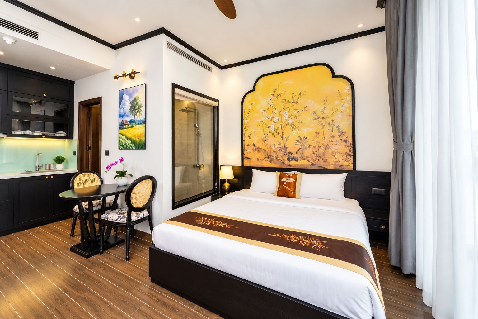 Quarto de hotel com cama, escrivaninha, cadeira, chuveiro e uma pintura grande na parede.