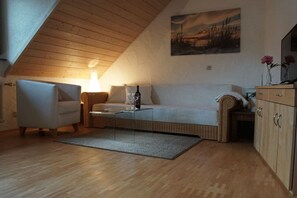 A cozy living room with a sofa, a chair, a coffee table, and a cabinet. - Holiday apartment with 2 bedrooms (Hayingen-Anhausen)