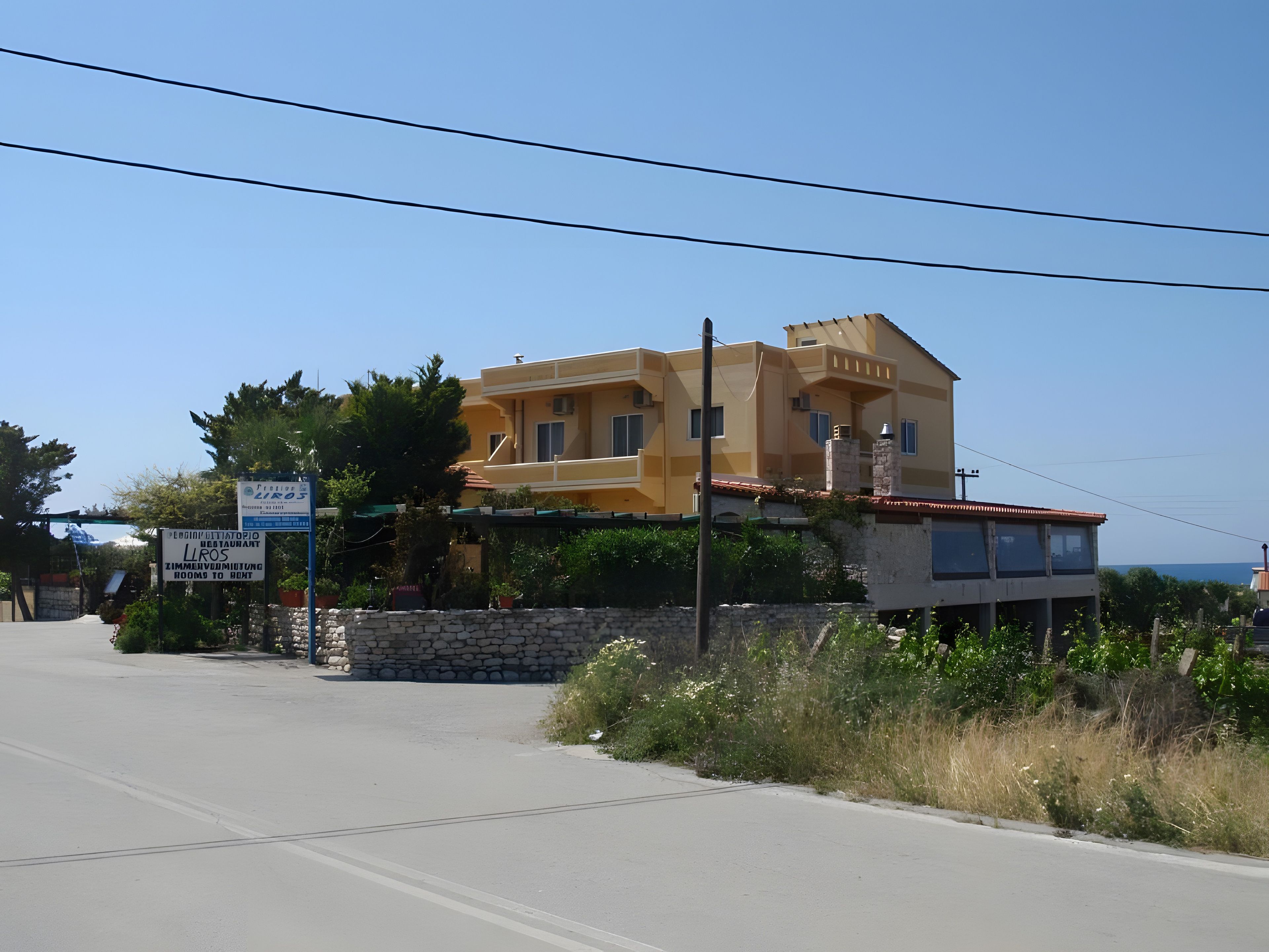 Un bâtiment à deux étages, doté d’un toit plat et d’un mur en pierre à l’avant.