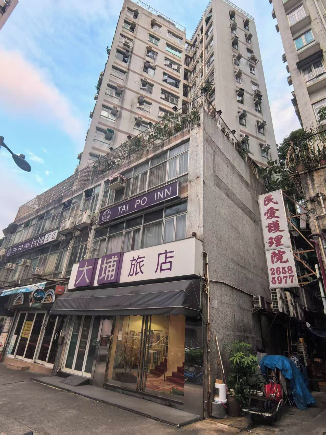 A multi-story building with a visible hotel named 'Tai Po Inn' on the ground floor.