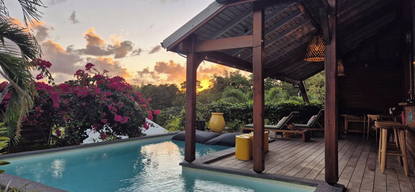 A pool area with lounge chairs and a covered seating area.
