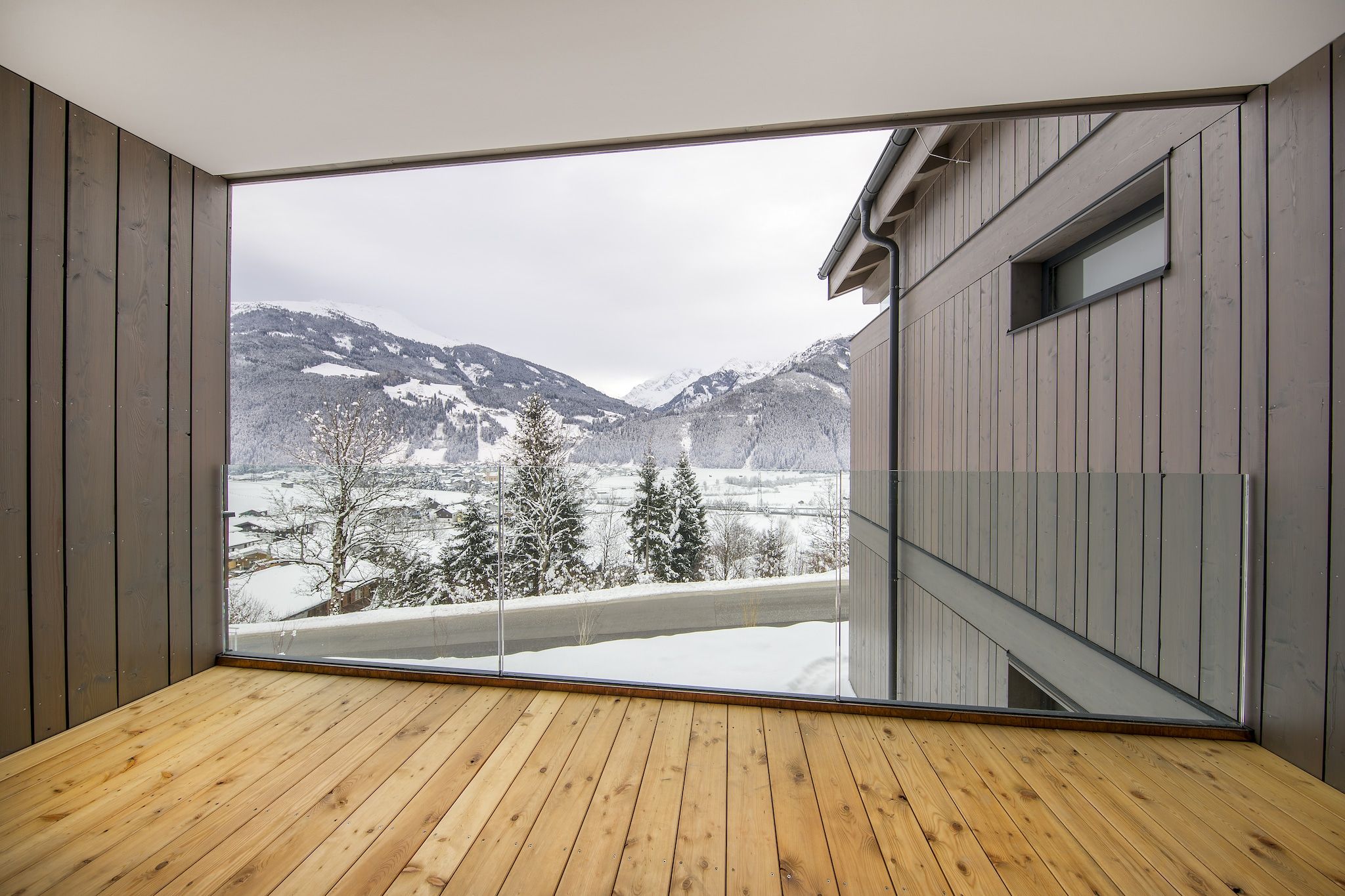 Una habitación con un gran ventanal que da a una vista nevada de la montaña.