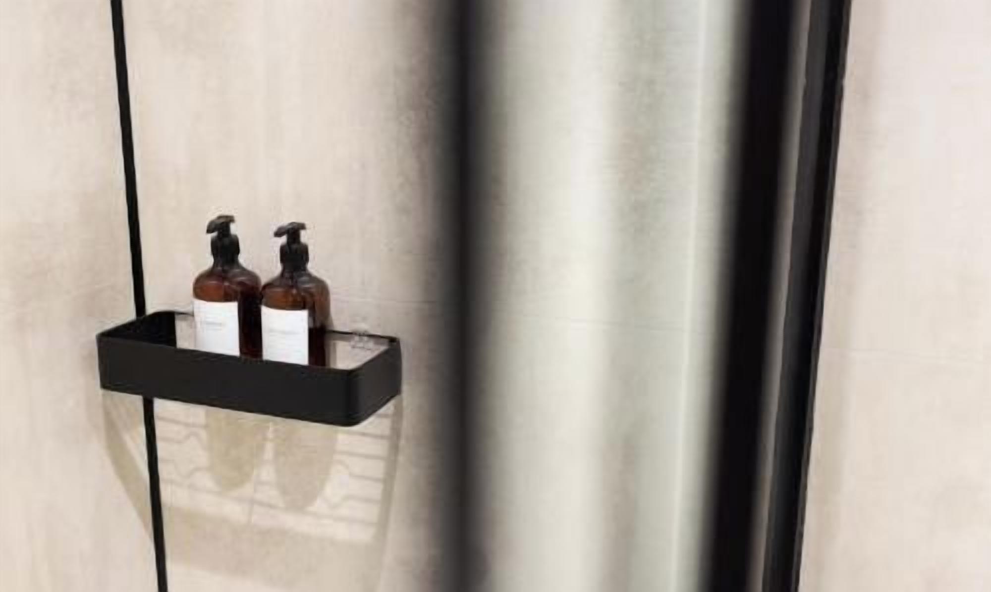 A black shelf with two bottles of liquid soap and a bottle of lotion.
