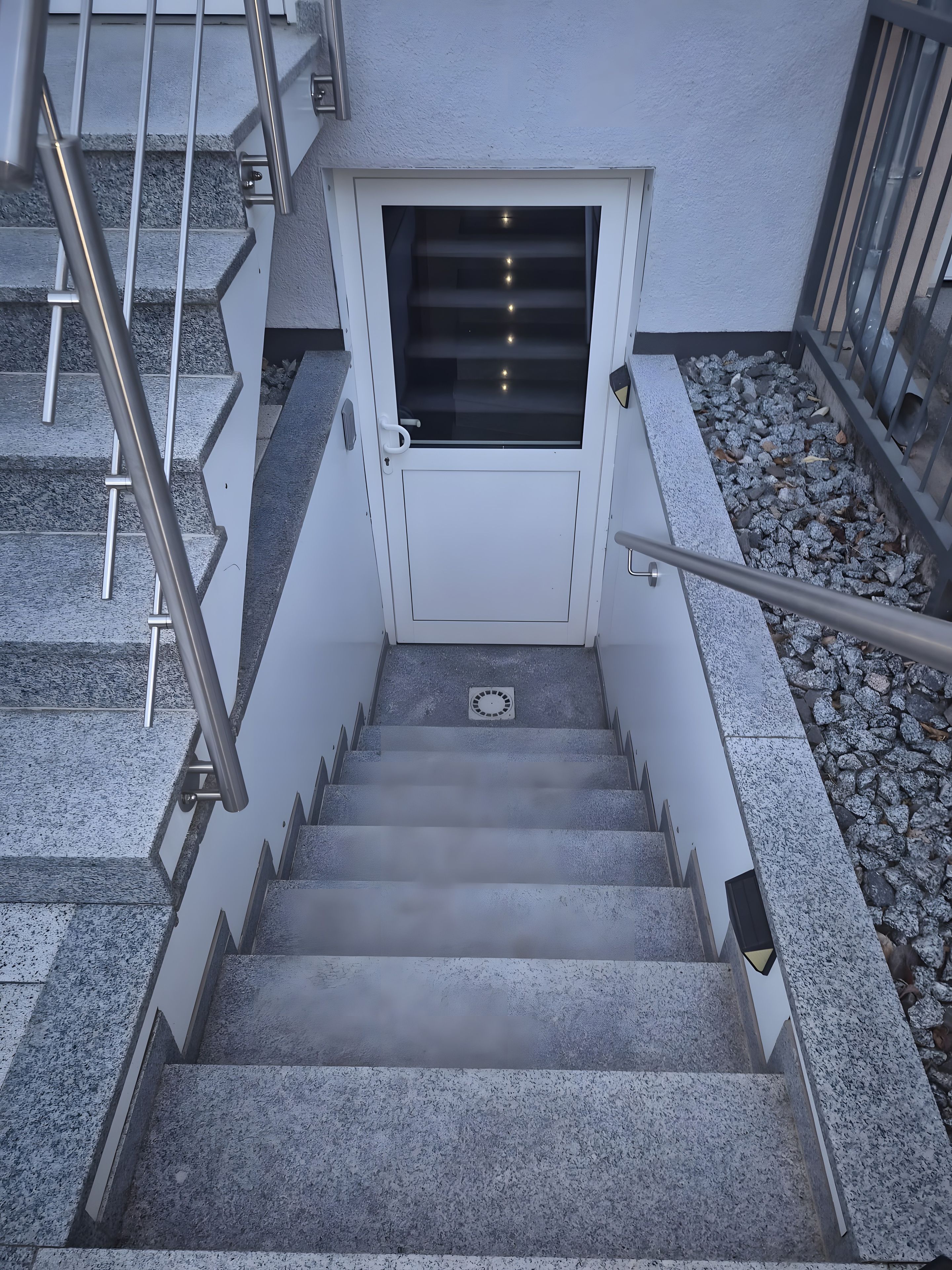 A staircase with metal railings and a door with a window.