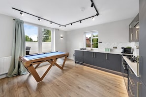 A modern kitchen with a pool table, large windows, and a view of the outdoors. - 2bedroom 2bathroom Penthouse Wembley Stadium (Wembley)