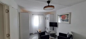 Une chambre d’hôtel avec un lit, un bureau, une chaise, une télévision et un tableau au mur.