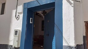Een deur met een blauw kozijn, leidend naar een binnenruimte.