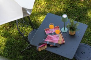Ein Tisch mit einem kleinen Topfpflanzen, einer Kerze und zwei Gläsern Orangensaft.