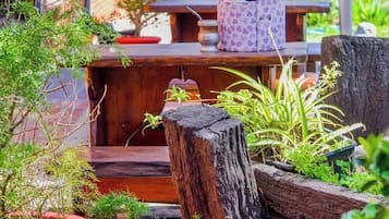 Una terraza de madera con plantas en macetas y un área de estar al aire libre de estilo rústico.