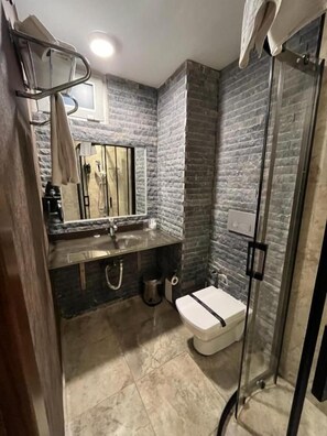 A compact bathroom with a shower, a toilet, and a sink with a mirror. - Weingart Port Seaside Hotel (Istanbul)