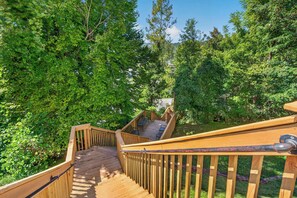 A wooden deck with a staircase leading to a covered outdoor area with seating. - Romance , Free Tickets Everyday, Walk 2 Downtown (Gatlinburg)