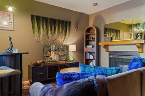 A cozy living room with a fireplace, a television, and a bookshelf. - Romance , Free Tickets Everyday, Walk 2 Downtown (Gatlinburg)