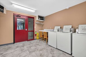 A laundry room with a red door, a fire extinguisher, and a yellow safety sign. - Romance , Free Tickets Everyday, Walk 2 Downtown (Gatlinburg)
