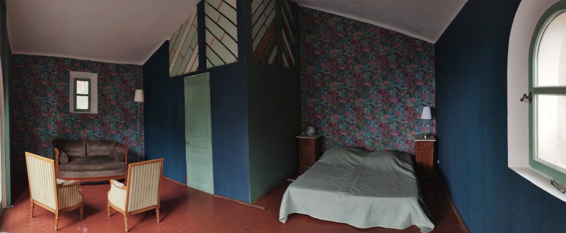 Une chambre à coucher avec un lit, deux chaises, une commode et une fenêtre.