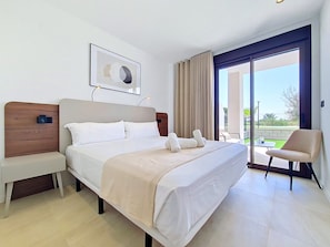 Ein Hotelzimmer mit Bett, Nachttisch, Stuhl und Blick ins Freie.