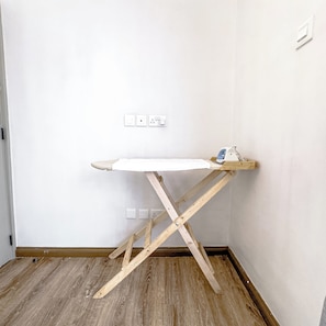 A corner room with a wooden ironing board and a small ironing board on the floor. - Kilimani Nairobi Luxury Stay | Pool, Gym, Sauna | 1 bedroom (Nairobi)