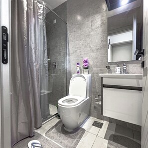 A modern bathroom with a toilet, shower, and sink. - Kilimani Nairobi Luxury Stay | Pool, Gym, Sauna | 1 bedroom (Nairobi)